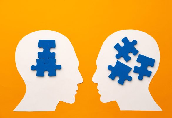 Papercut head silhouette with puzzle pieces on yellow background top view